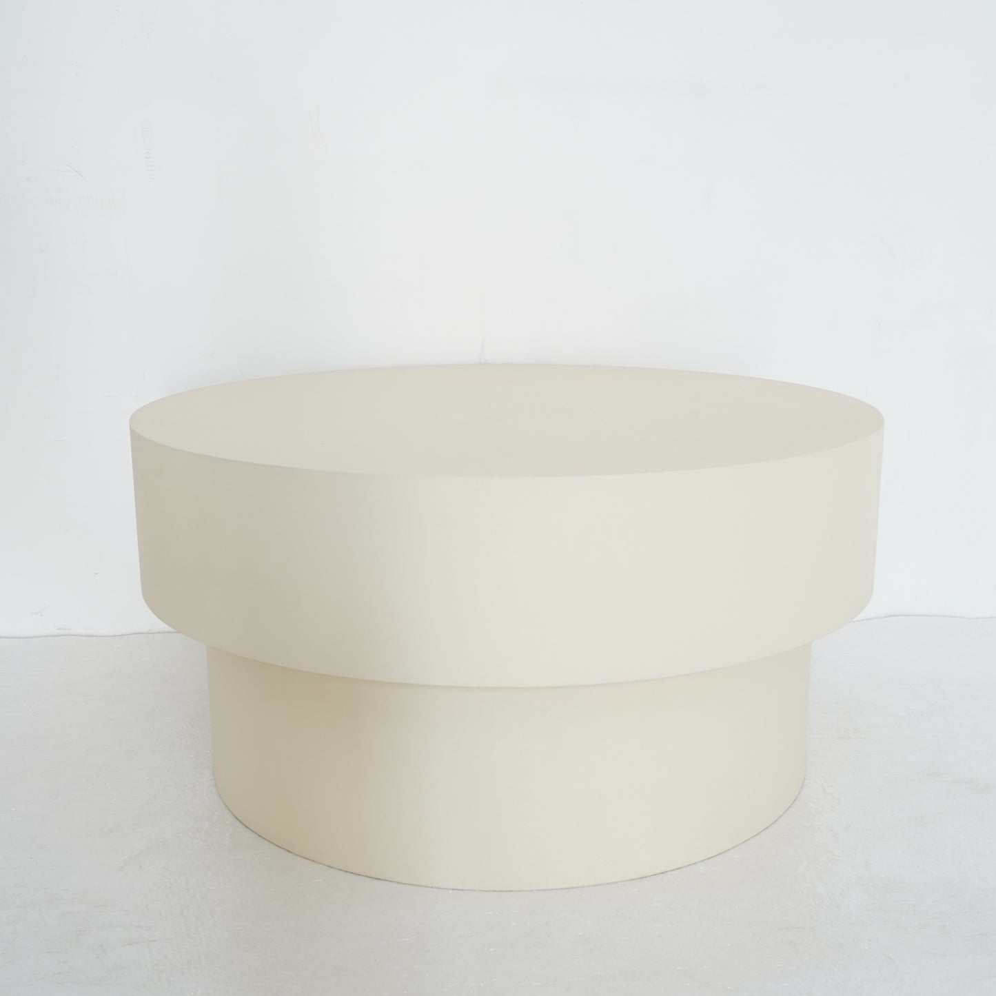 Round microcement cofee table from the Andre Collection, 90cm diameter, with smooth matte finish and minimalist silhouette set in a modern living space.