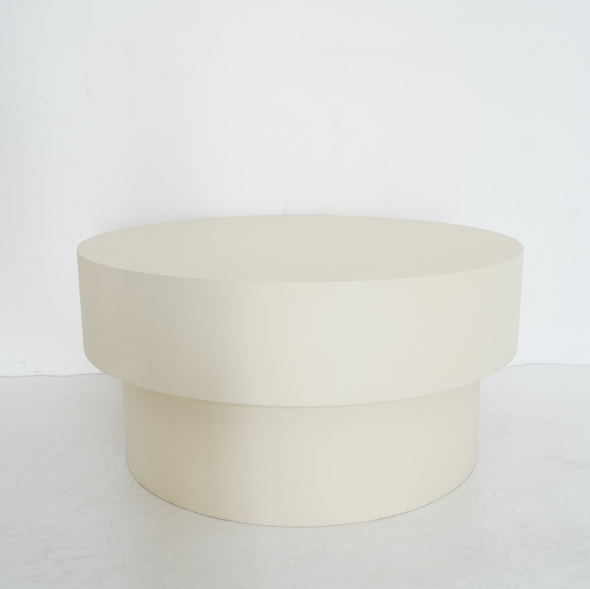 Round microcement cofee table from the Andre Collection, 90cm diameter, with smooth matte finish and minimalist silhouette set in a modern living space.