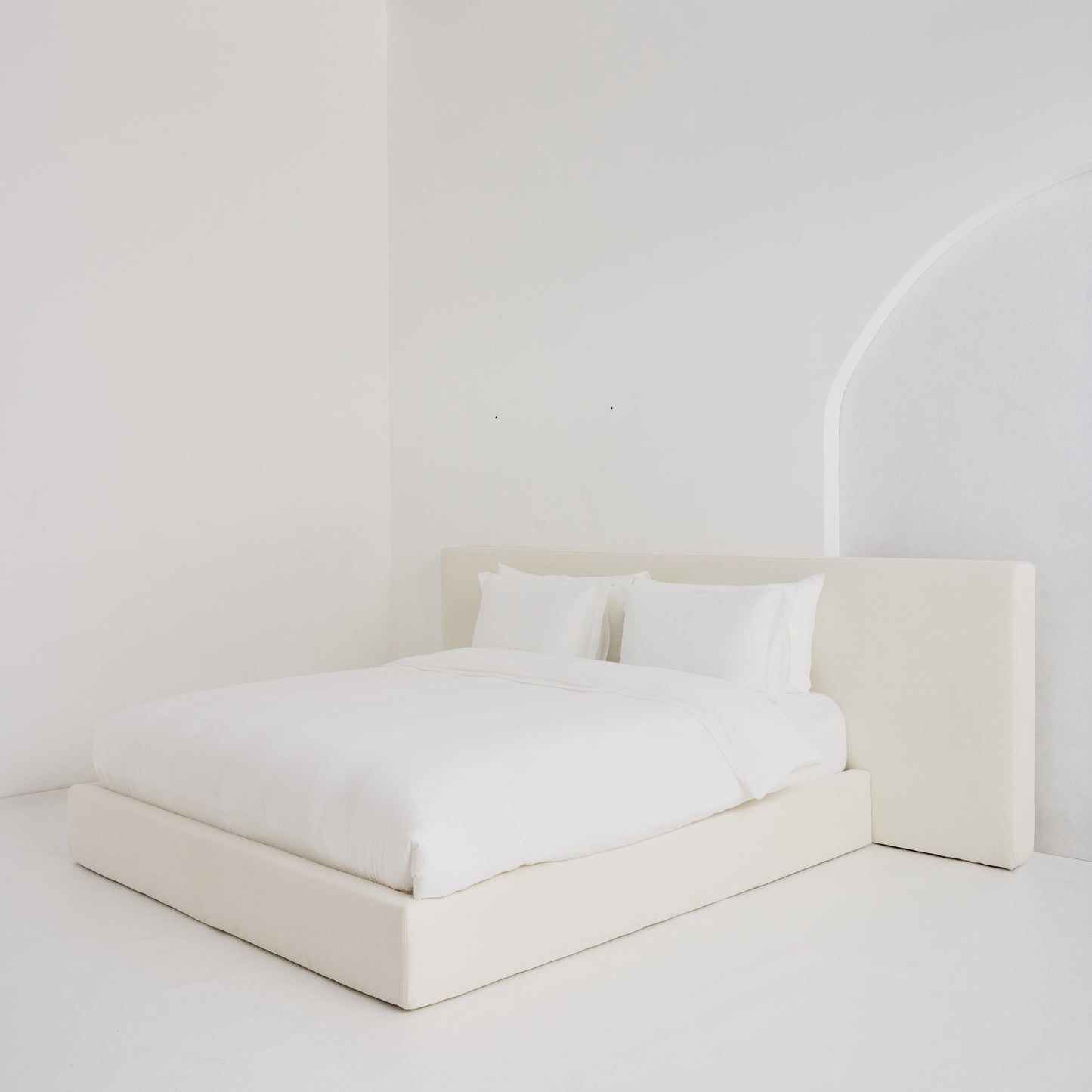 Custom-made Coastal Bed with oversized headboard, styled in serene neutral fabric for a relaxed, luxurious bedroom aesthetic.