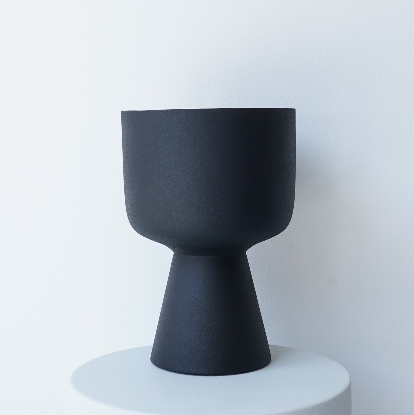 Decorative iron pots in black, chocolate, and snow finishes for modern interiors.