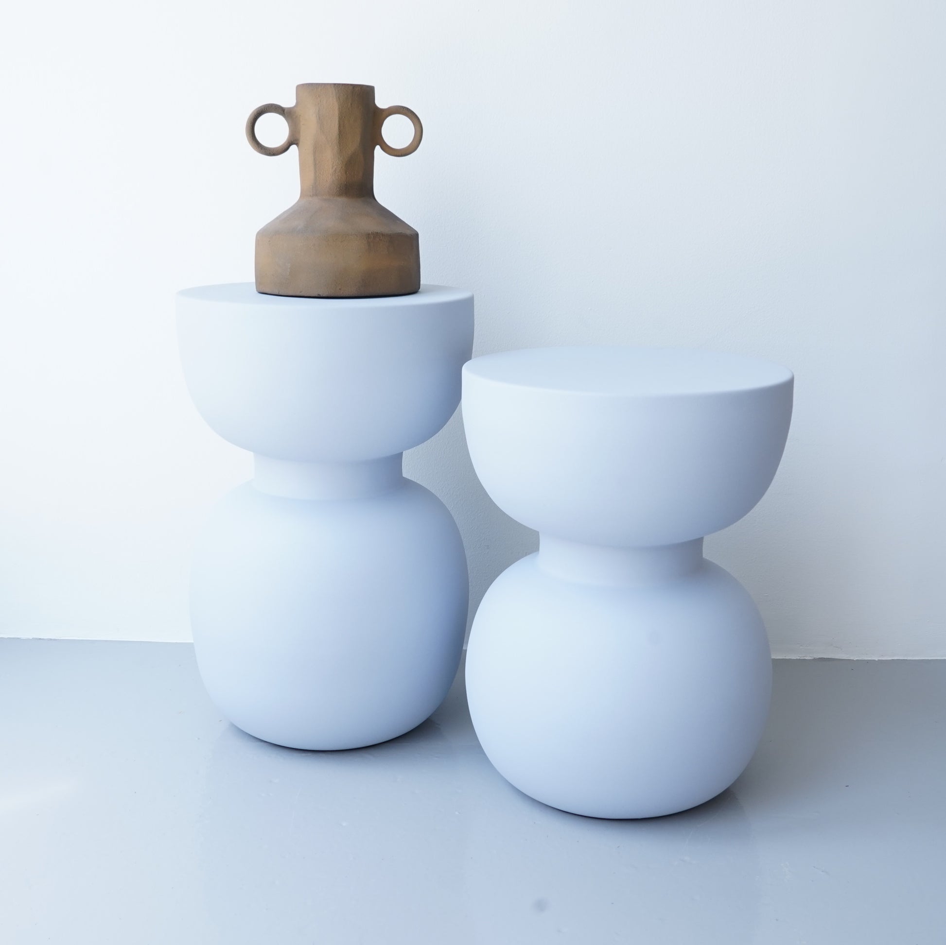 Note & Tone Side Tables in iron, Fog and Snow finishes, styled as a nested duo beside a modern sofa in Tribe Dubai showroom.