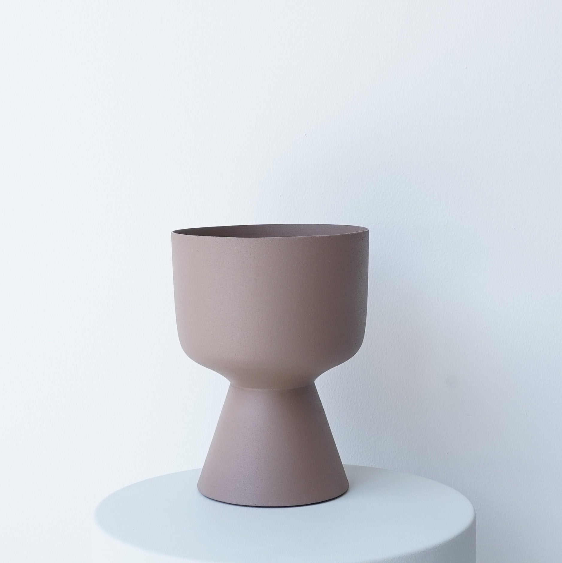 Decorative iron pots in black, chocolate, and snow finishes for modern interiors.
